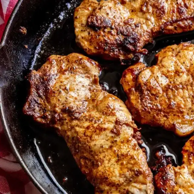 Pork frying up in a pan.