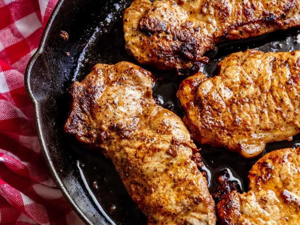 Pork frying up in a pan.