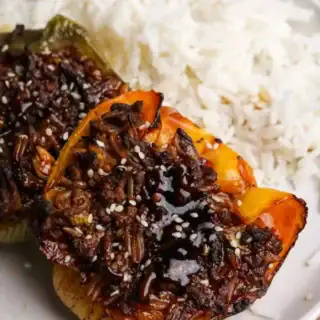 Beef and rice filled bell peppers with side of rice.