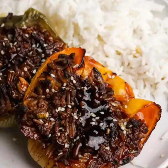 Beef and rice filled bell peppers with side of rice.
