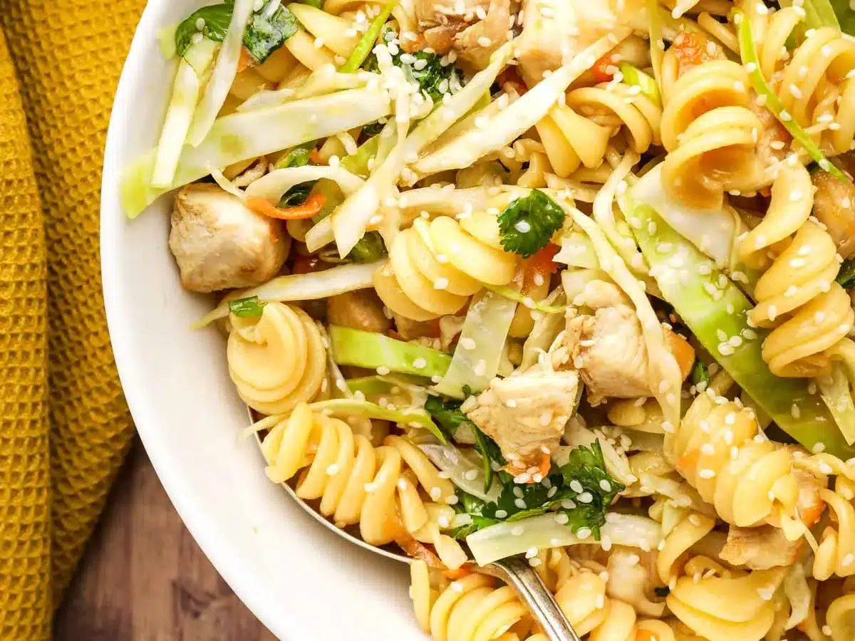 Pasta salad in bowl with chicken and veggies.