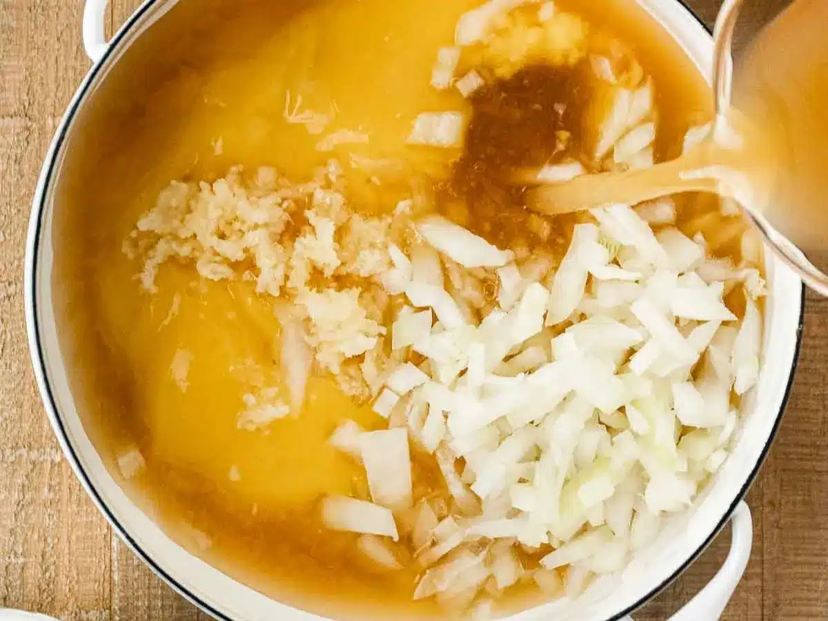 Cream of chicken soup, broth, onion, and garlic in pot.