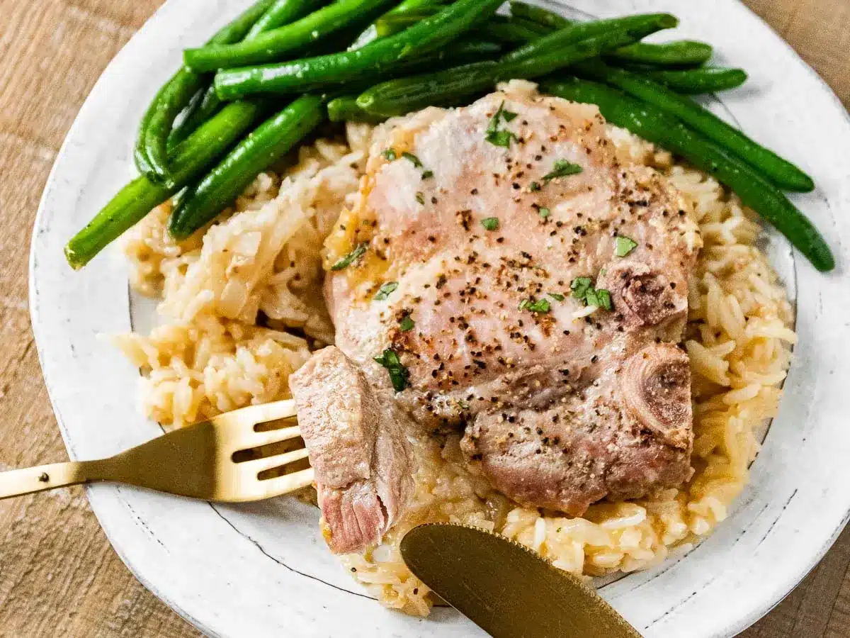 Dinner plate with pork, rice, and green beans.
